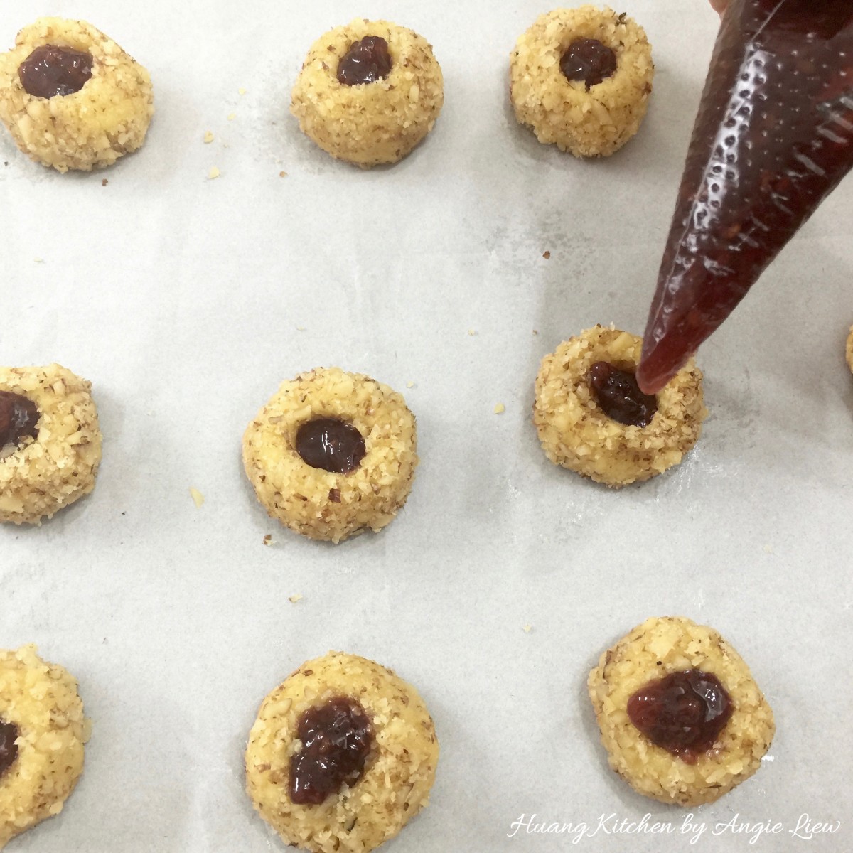 Christmas Thumbprint Cookies Recipe - pipe with raspberry jam