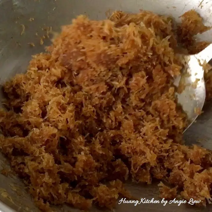 Mix grated coconut with palm sugar syrup.