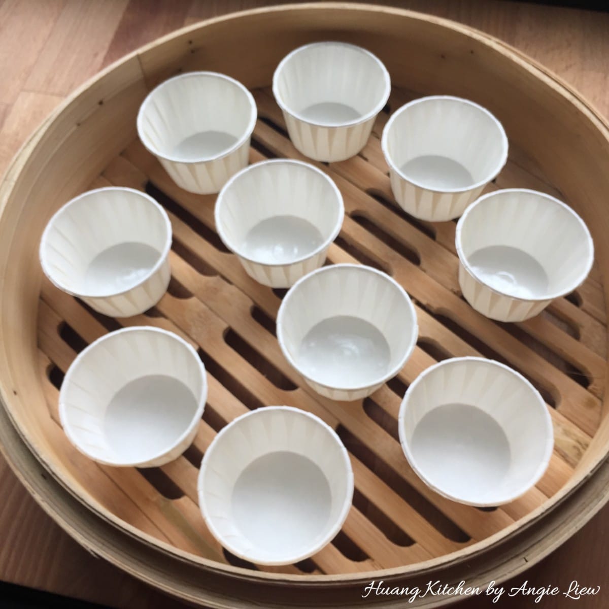 Line paper cups onto bamboo steamer.