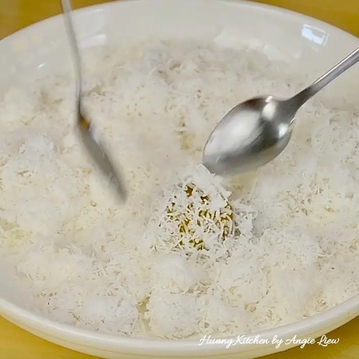 Roll cooked onde onde with grated coconut.