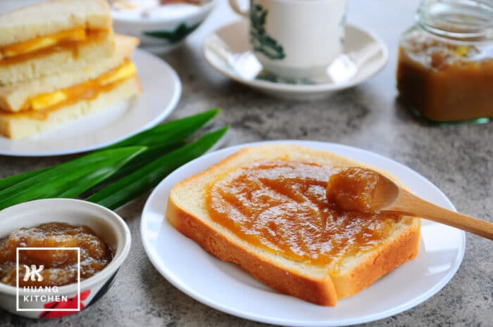 Homemade Caramel Kaya Recipe by Huang Kitchen - Toast with kaya spread on wooden spoon, with coffee cup kaya thick toast in background