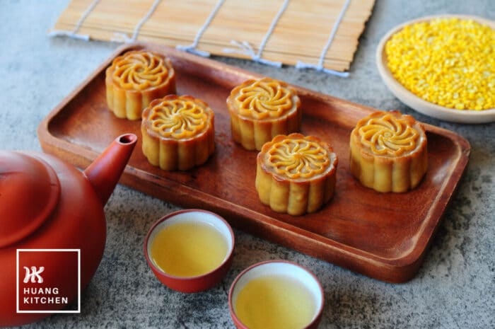 Baked Durian Mung Bean Paste Mooncake Recipe by Huang Kitchen - Mooncakes on a wooden tray with chinese tea and mung beans in background