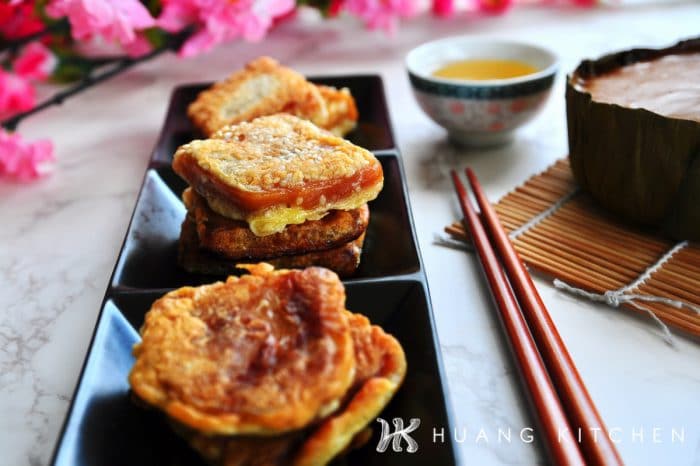 Pan Fried Nian Gao Recipe by Huang Kitchen - Arranged and stacked fritters with chopsticks, chinese tea on marble background