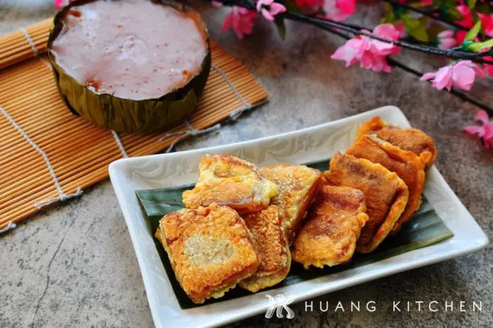 Pan Fried Nian Gao Recipe by Huang Kitchen - Arranged on plate with banana leaf with cherry blossom flowers, Kuih Bakul and bamboo background