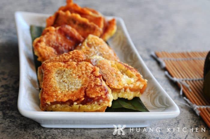 Pan Fried Nian Gao Recipe by Huang Kitchen - crispy fritters with egg batter and white sesame seeds, arranged on a plate